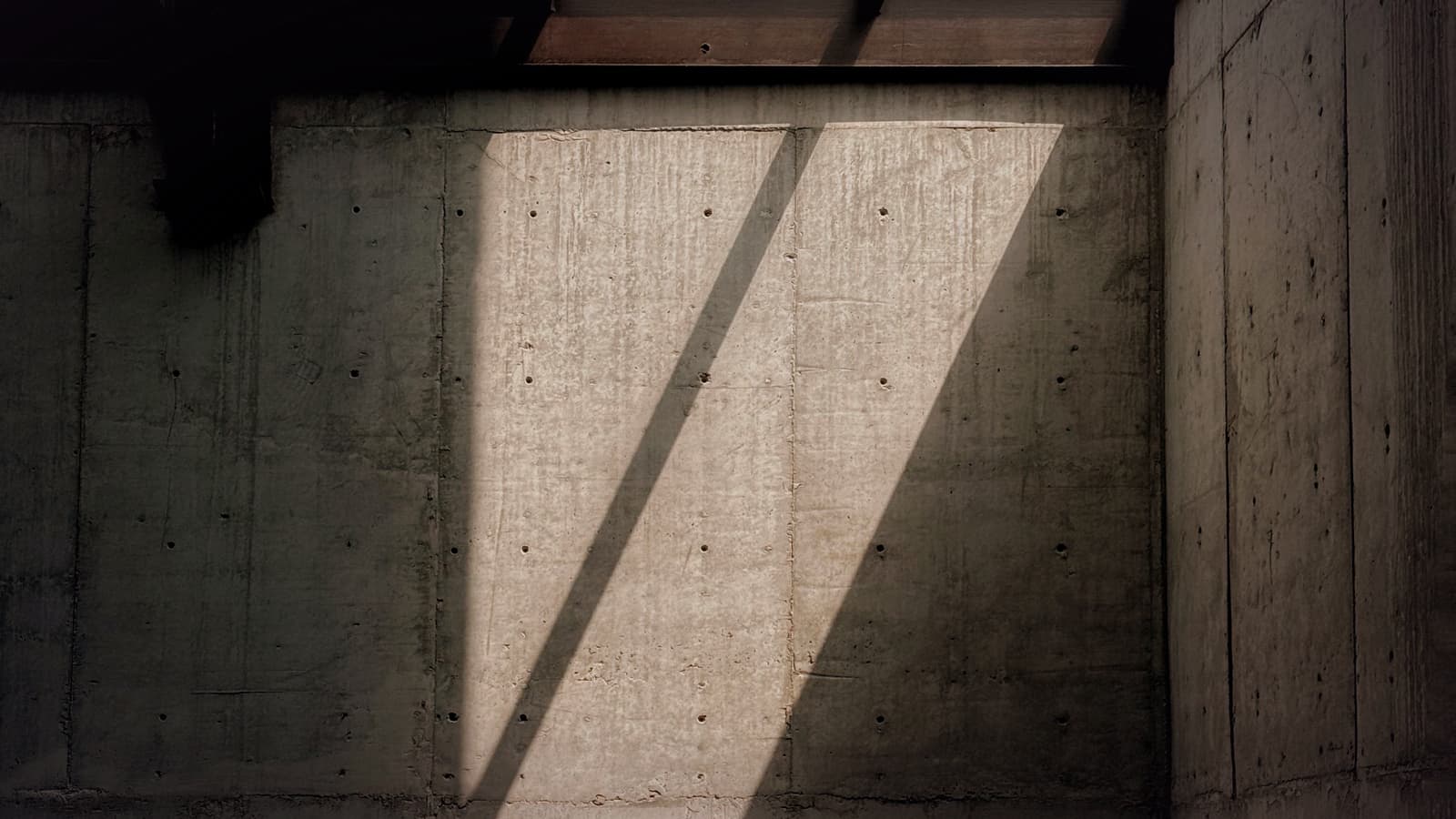 Daylight falling across a concrete wall